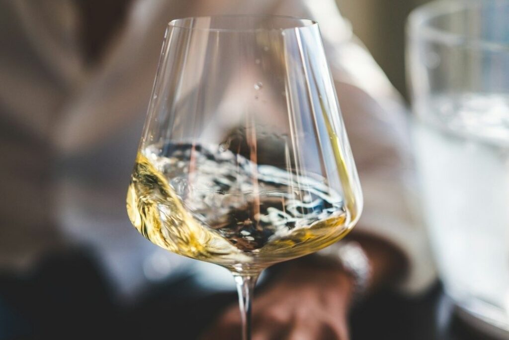 Close-up of pale wine swirling in a clear stemmed glass