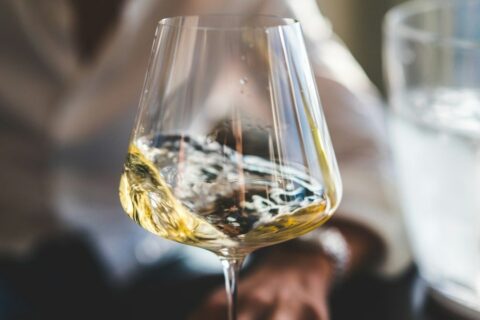Close-up of pale wine swirling in a clear stemmed glass